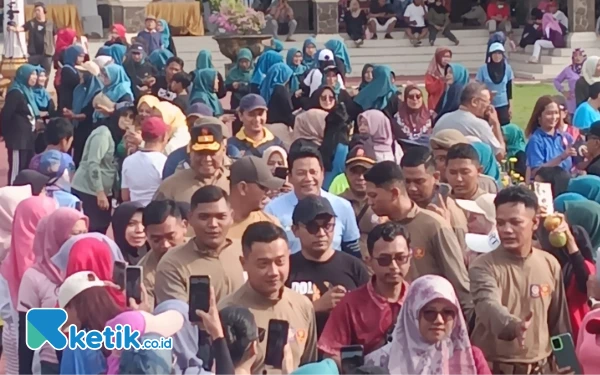 Foto Plt Bupati Sidoarjo Subandi (kaus biru) didampingi Kepala Satpol PP Kabupaten Sidoarjo Yany Setyawan menuju panggung sosialisasi stop peredaran rokok ilegal di Alun-Alun Sidoarjo. (Foto: Fathur Roziq/Ketik.co.id)