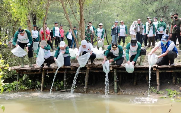 Foto Khofifah bersama sejumlah pejabat melepaskan benih ikan dikawasan hutan mangrove. ( Foto : Humas Pemprov Jatim )