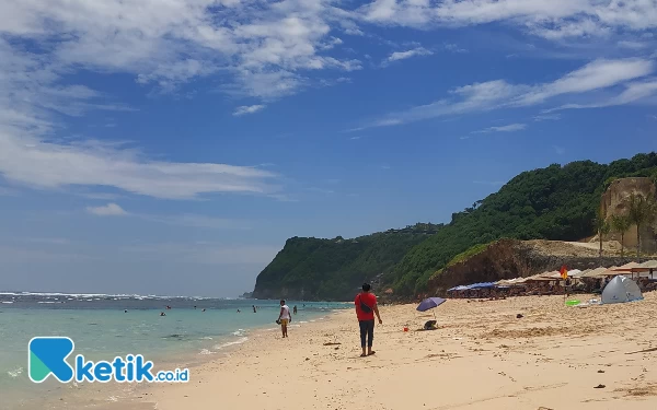 Foto Hamparan pasir putih dan pemandangan bukit karang yang indah di Pantai Melasti. (Foto: Husni Habib/Ketik.co.id)